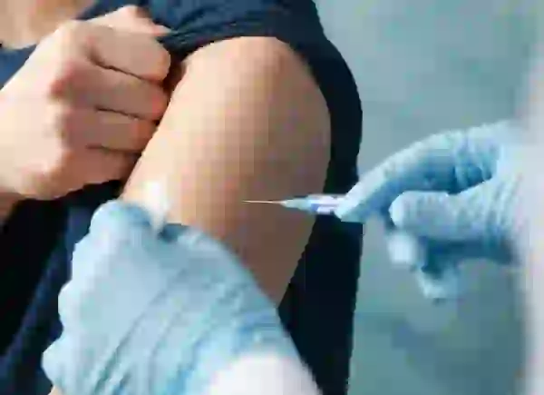 Focus on arm of patient receiving a vaccine