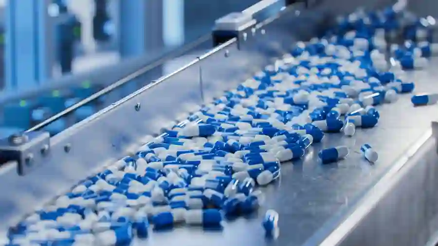 Pharmaceutical capsules exiting a piece of equipment