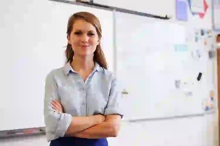Female teacher standing in front of a whiteboard, smiling